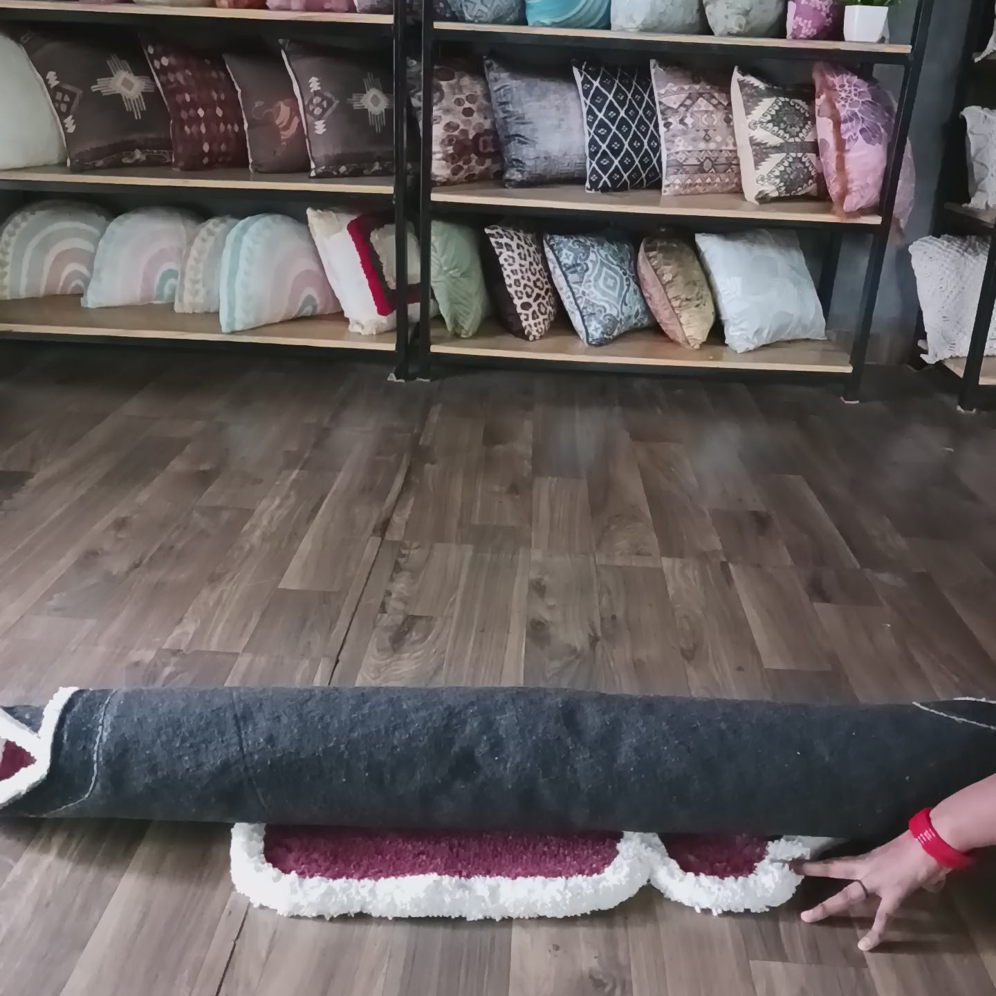 Person unrolling a plush luxury rose carpet with a white 3D border in a home decor setting.
